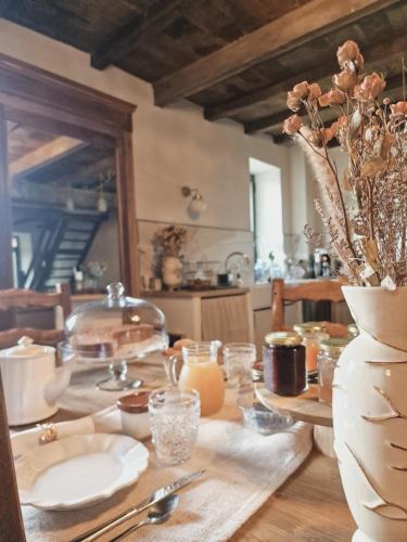 una mesa con platos y velas y un jarrón con flores en Casa Nanuccia, en Bastelica