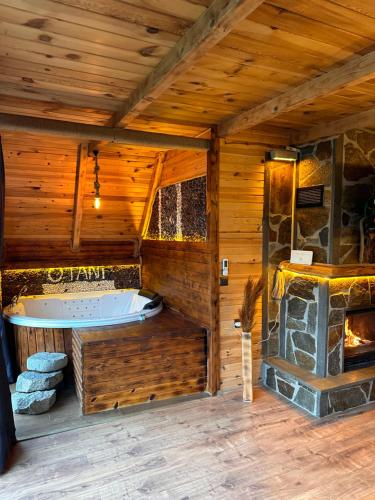 une grande chambre avec baignoire dans une maison en bois dans l'établissement OTANİ DAĞ EVLERİ, à Çamlıhemşin