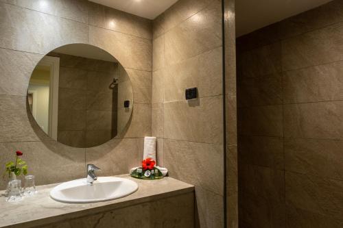 y baño con lavabo y espejo. en Djerba Sun Beach, Hotel & Spa en Houmt El Souk