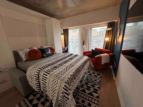 a bedroom with a bed with a black and white blanket at Bel Appartement au centre-ville Montréal in Montreal
