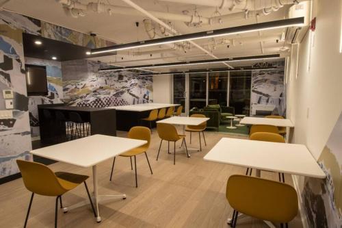 a group of tables and chairs in a room at Downtown Montreal Premium Cozy Studio in Montréal