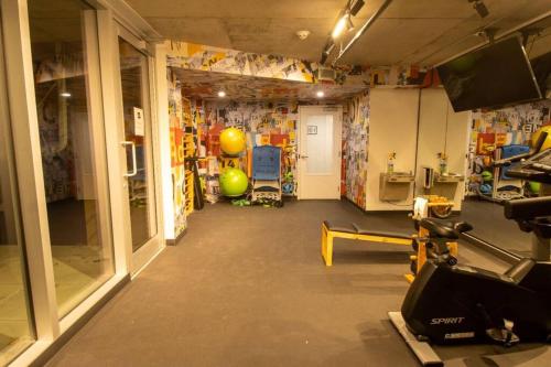 a room with a gym with a treadmill and a ball at Downtown Montreal Premium Cozy Studio in Montréal