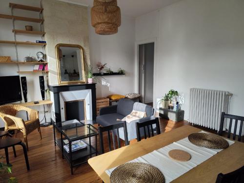un salon avec une table et une cheminée dans l'établissement Charming apartment Bordeaux center, à Bordeaux