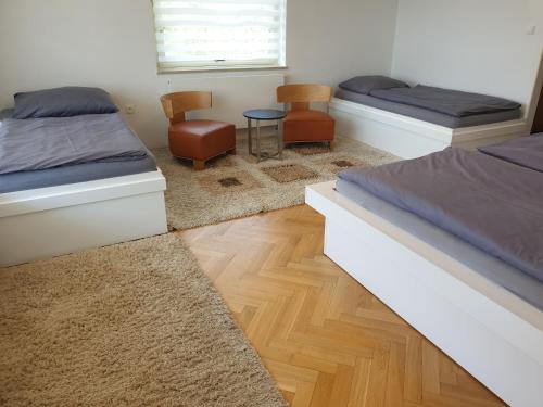 KozÃ¡rovice的住宿－Vilas & Wellness Resort Orlík，一间卧室配有两张床和一张桌子及椅子
