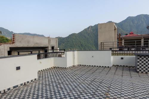 a rooftop of a building with mountains in the background at Himalayan Haven: 2BHK Luxury Apartment in Rishīkesh