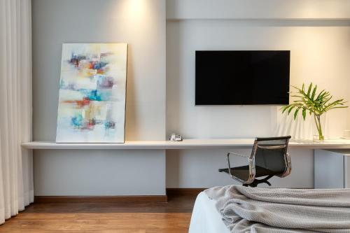 a room with a desk with a tv and a chair at Mercure Belo Horizonte Lourdes in Belo Horizonte