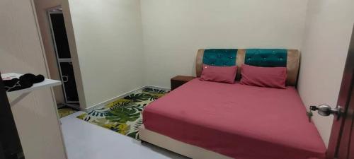- une chambre avec un lit doté de draps roses et d'oreillers roses dans l'établissement Homestay Kaklong, à Kuala Terengganu