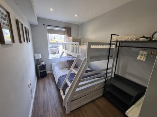 ein kleines Zimmer mit 2 Etagenbetten und einem Fenster in der Unterkunft The Cove Apartment, Portstewart near Prom, Parking in Portstewart