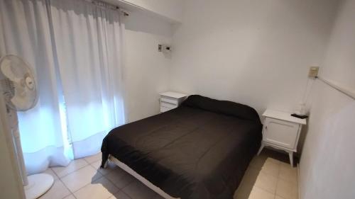 a small bedroom with a bed and a window at 3 Ambientes Mar del Plata in Mar del Plata