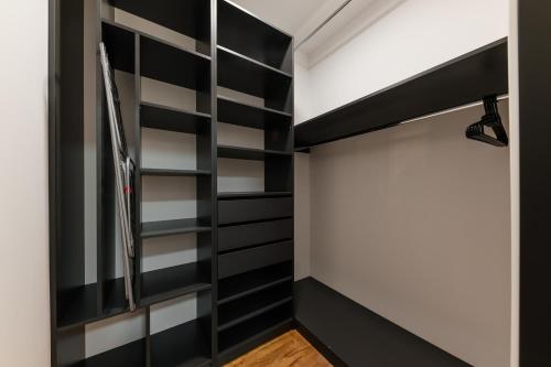 a walk in closet with black and white shelving at Luxury Apartments Laborca in Uzhhorod