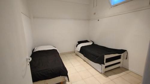 a small room with two beds and a window at 3 Ambientes Mar del Plata in Mar del Plata