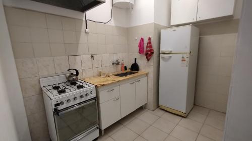 a kitchen with a stove and a white refrigerator at 3 Ambientes Mar del Plata in Mar del Plata
