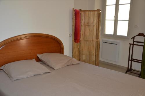 um quarto com uma cama com duas almofadas e uma janela em L'Arche de Noé em Aubenas
