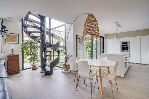 uma sala de estar com uma mesa e uma escada em espiral em Spacious Bordeaux family home with swimming pool em Bordeaux