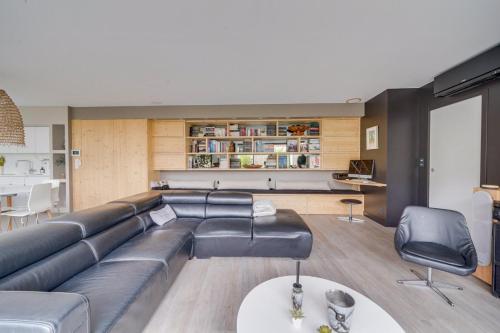 uma sala de estar com um sofá de couro e uma mesa em Spacious Bordeaux family home with swimming pool em Bordeaux