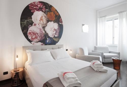 a bedroom with a large white bed with a painting on the wall at DUOMO VIEW - 2 min from Duomo Amazing location in Milan