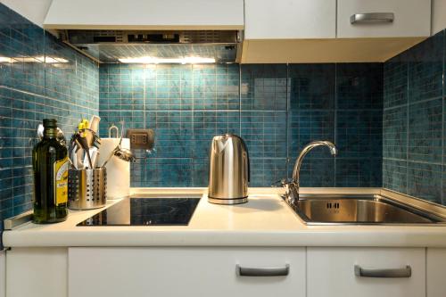 a kitchen with a stainless steel sink and blue tiles at DUOMO VIEW - 2 min from Duomo Amazing location in Milan