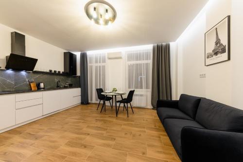 a living room with a black couch and a table at Luxury Apartments Laborca in Uzhhorod