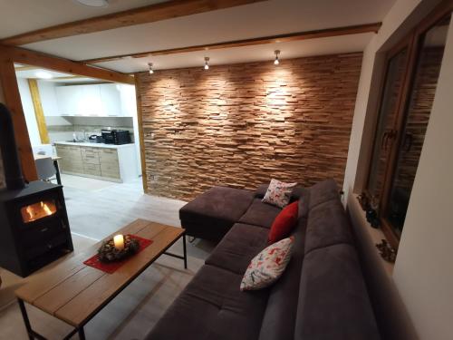 a living room with a couch and a brick wall at Brvnara Vidra in Pale