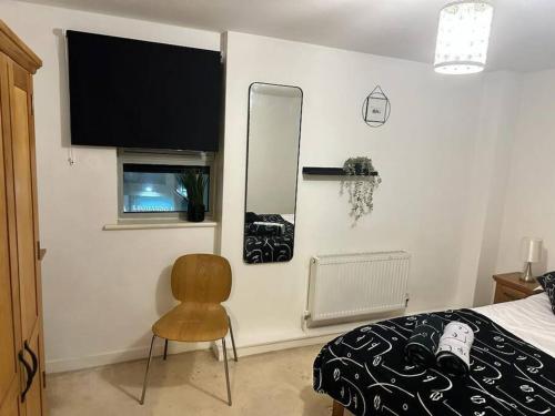 a bedroom with a bed and a mirror and a chair at The Raleigh Apartment Central Plymouth 2 Bedroom in Plymouth