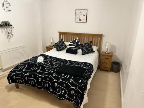 a bedroom with a bed with black and white sheets and pillows at The Raleigh Apartment Central Plymouth 2 Bedroom in Plymouth