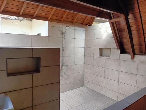 a bathroom with a shower with a glass door at Villa Lumbung Petanahan in Jembrana