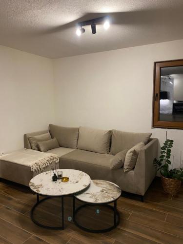 a living room with a couch and two tables at WoodAvenue in Blidinje