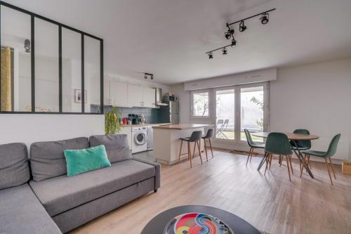 ein Wohnzimmer mit einem Sofa und einem Tisch sowie eine Küche in der Unterkunft Pleasant flat in Bordeaux with terrace and parking in Bordeaux