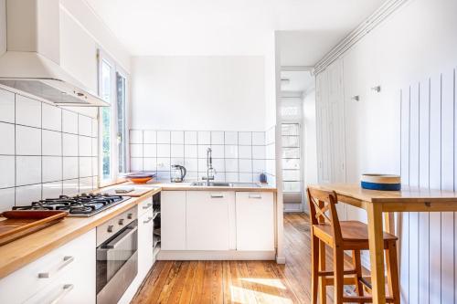 a kitchen with white cabinets and a stove top oven at Beautiful apartment in Bordeaux with garden in Bordeaux