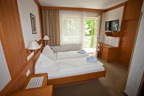 Schlafzimmer mit einem großen weißen Bett und einem Fenster in der Unterkunft Seevilla Wochinz in Faak am See