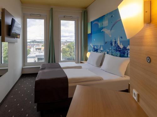 フルダにあるB&B Hotel Fulda-Cityの大きなベッドと窓が備わるホテルルームです。