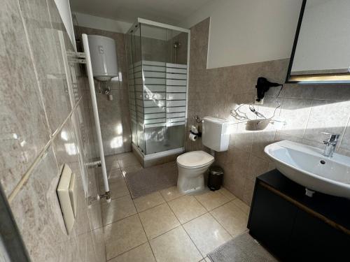 y baño con ducha, aseo y lavamanos. en Coy Apartments Vienna #3, en Viena