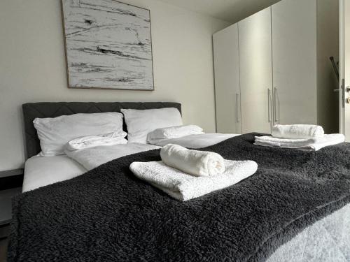 Una cama con toallas blancas encima. en Coy Apartments Vienna #3, en Viena