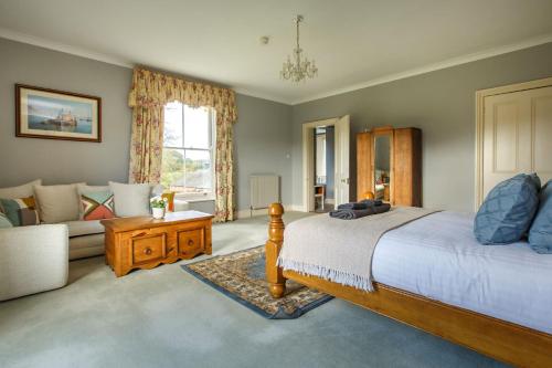 a bedroom with a bed and a couch at Saham Grove Hall by Group Retreats in West Bradenham