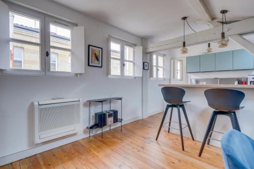 kuchnia z 2 stołkami barowymi i telewizorem w obiekcie Bel appartement Bordeaux centre Pey Berland w mieście Bordeaux
