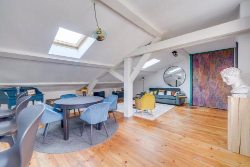 un salon avec une table, des chaises et un canapé dans l'établissement Bel appartement Bordeaux centre Pey Berland, à Bordeaux