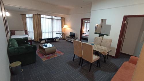 uma sala de estar com um sofá e uma mesa num quarto de hotel em Times Square Hotel Service Suite KL em Kuala Lumpur