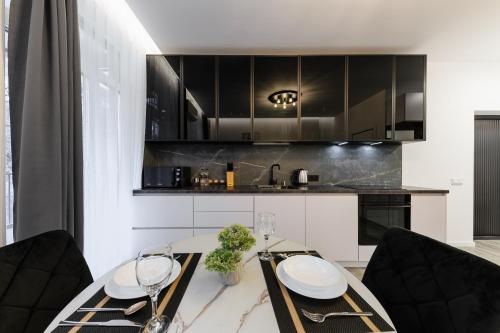 Luxury Apartments Laborca في أوجهورود: مطبخ مع طاولة مع كرسيين وكاونتر