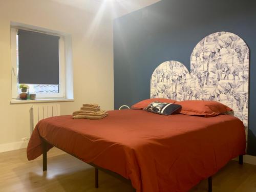 um quarto com uma cama com uma colcha laranja em Jungle Chic em Saint-Avold