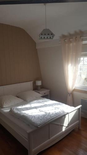 - un lit blanc dans une chambre avec fenêtre dans l'établissement Duplex avec 3 chambres à 30m de la plage, à Merlimont