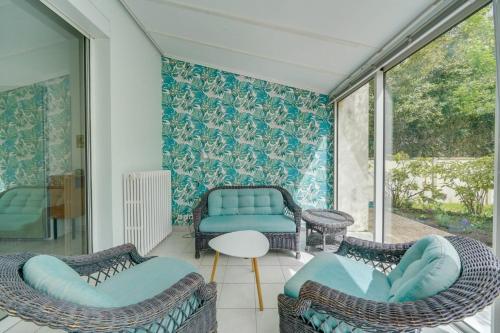 une chambre avec des chaises, un canapé et une table dans l'établissement Jolie maison au Bouscat avec jardin, à Le Bouscat