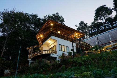 a house on a hill with a roof at สวนส่อผ่า&ฟาร์มสเตย์ in Mae Sai