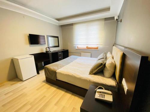 una piccola camera con letto e scrivania di ANİMOS BUTİK OTEL a Ankara