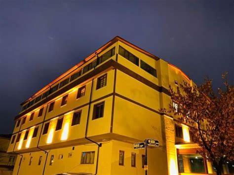 un edificio giallo con luci sopra di ANİMOS BUTİK OTEL a Ankara