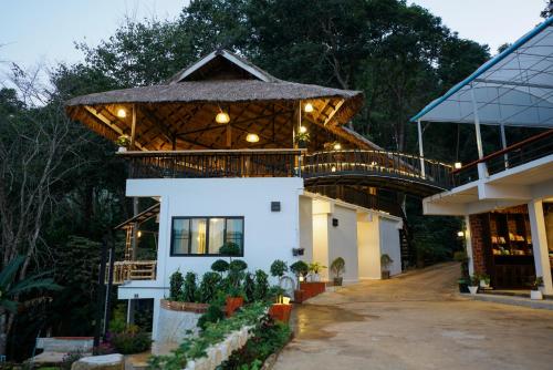 a house with a wooden roof and a walkway at สวนส่อผ่า&ฟาร์มสเตย์ in Mae Sai