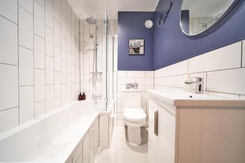 a bathroom with a toilet and a tub and a sink at Belfry House in Bristol