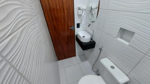a small bathroom with a toilet and a phone at Pousada Bomfim in Maceió