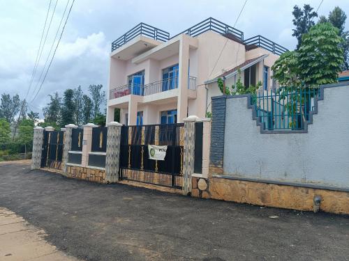 a house with a fence in front of it at HARRIET APARTHOTEL Kigali-NYARUTARAMA in Kigali