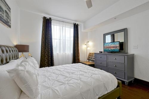 International Drive Luxury Condo في أورلاندو: غرفة نوم مع سرير وخزانة مع مرآة