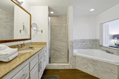 a bathroom with a tub and a sink and a shower at International Drive Luxury Condo in Orlando